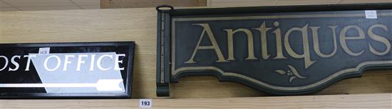 A glass Post Office sign and a wooden Antiques